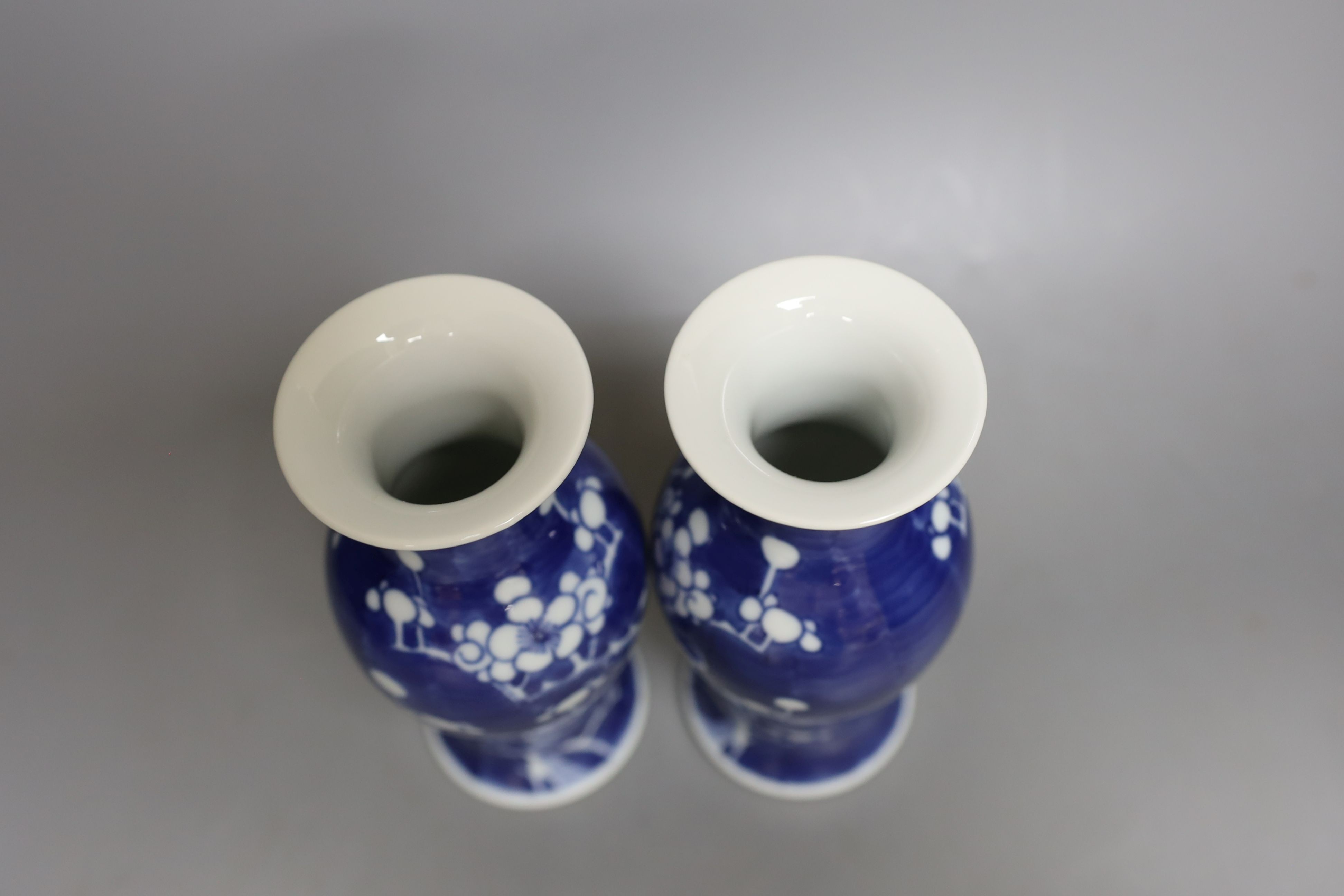 A pair of early 20th century Chinese prunus blue and white baluster form vases, 16 cms high.